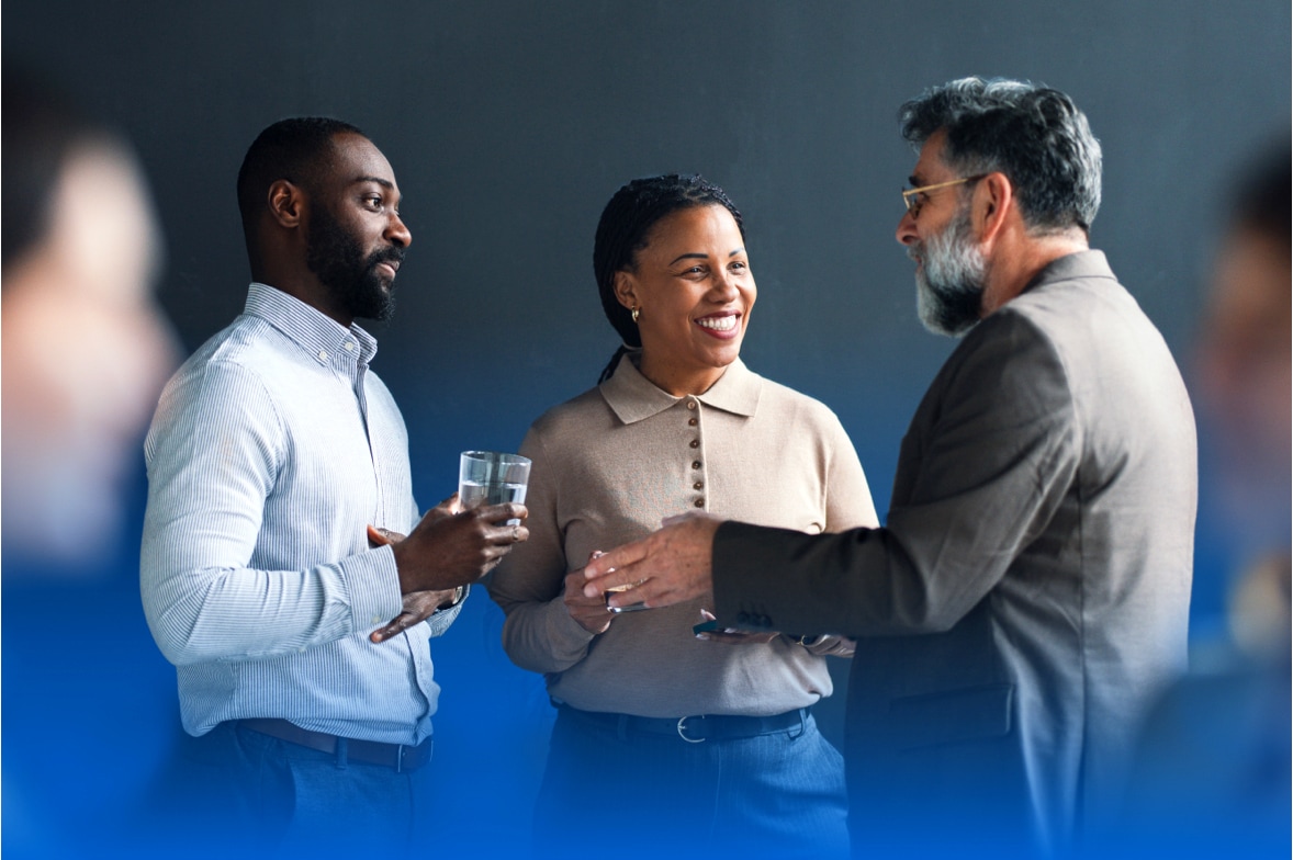three people standing with cocktails in a discussion